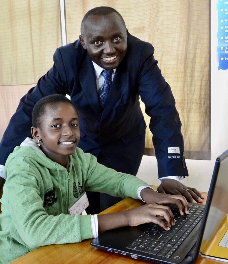 A man and boy are using a laptop