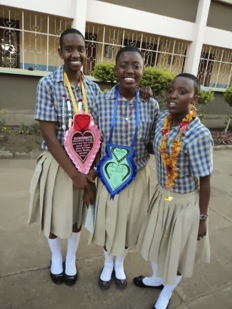 Three girls in school uniforms posing for a picture.