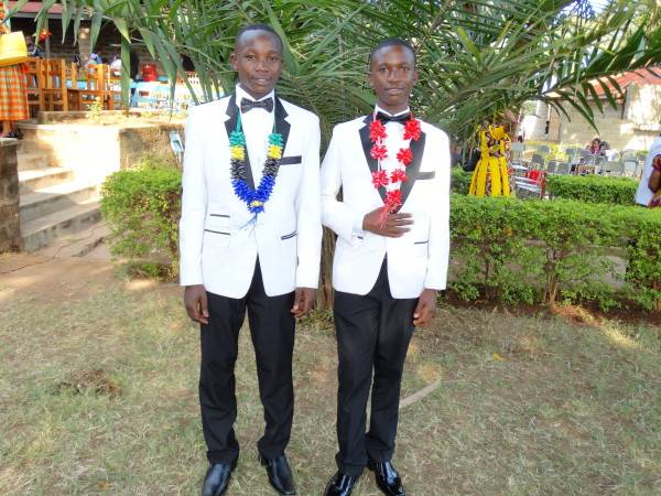 Two men in tuxedos standing next to each other.