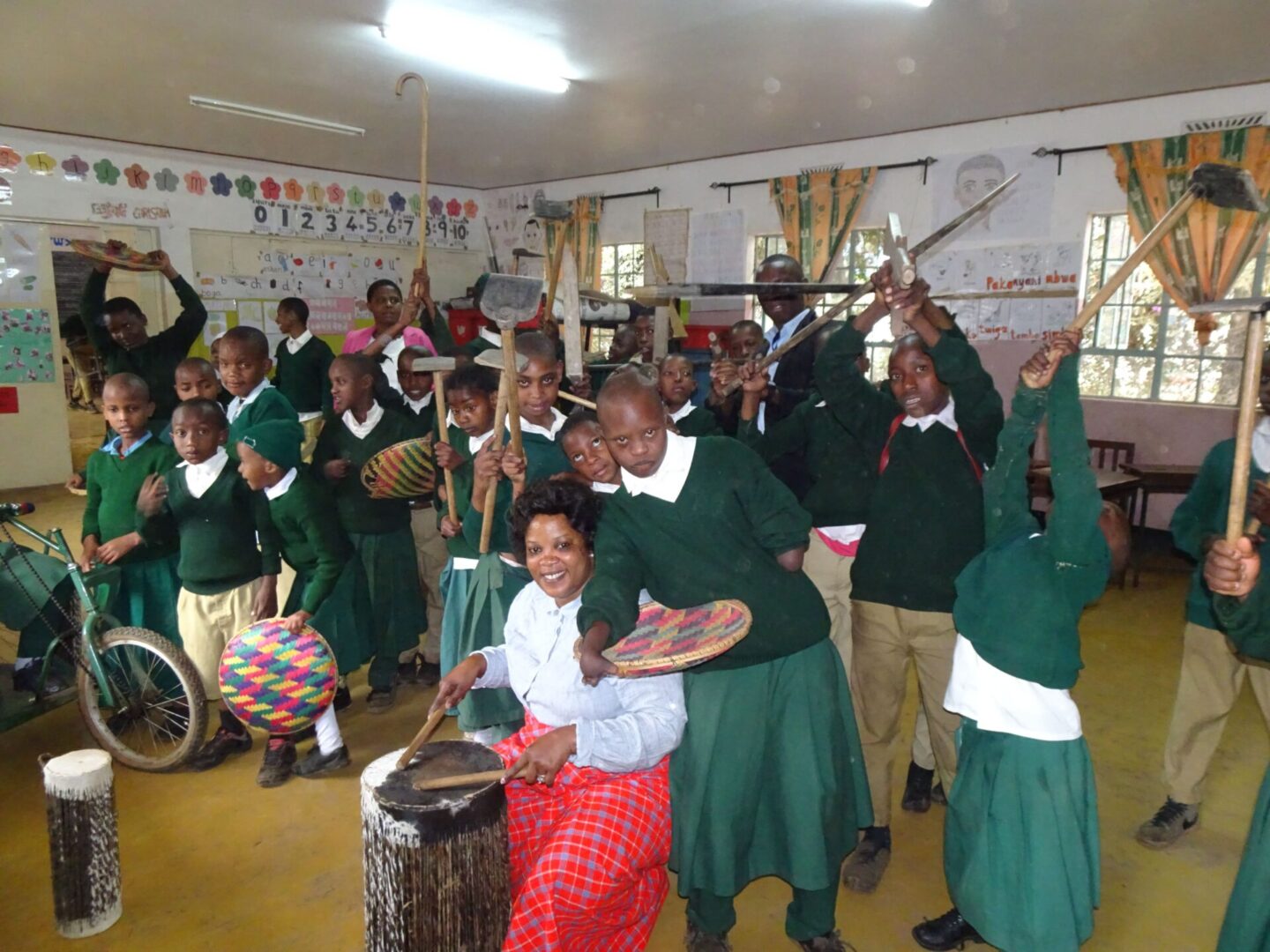 A group of people in green shirts and red skirts.