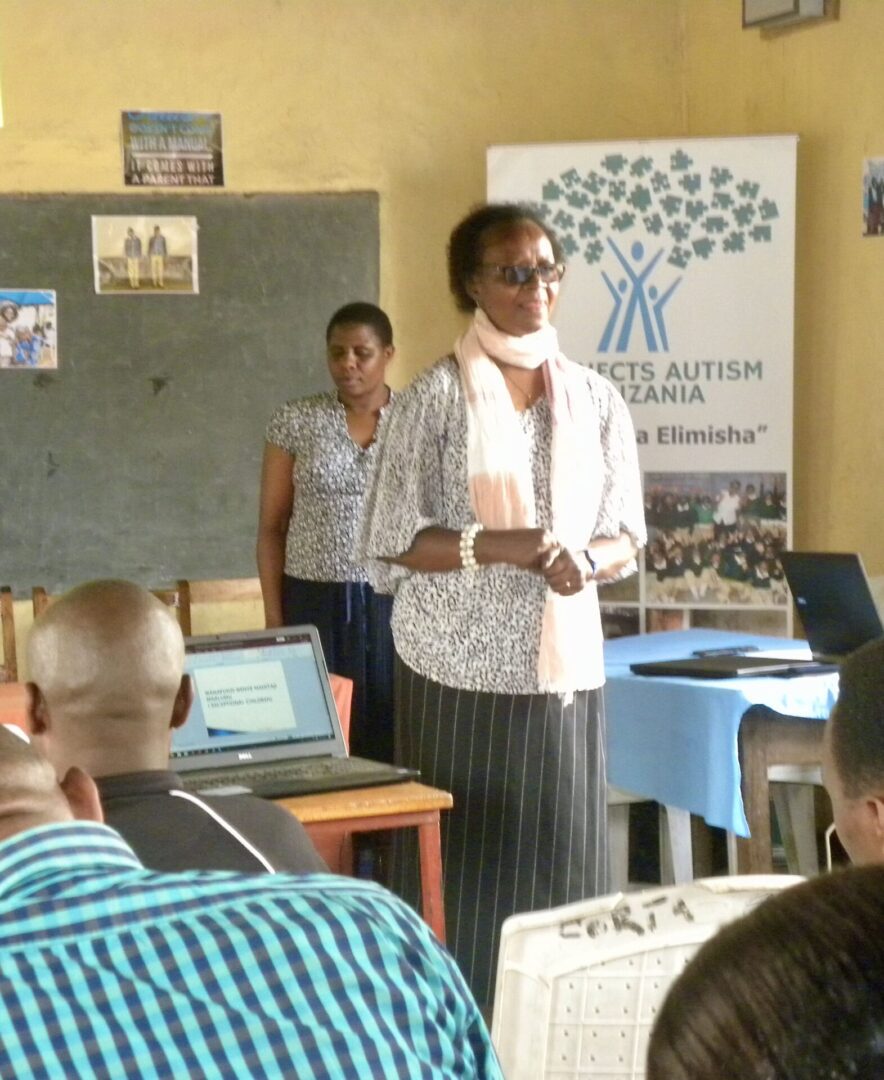 Two women are standing in front of a group.