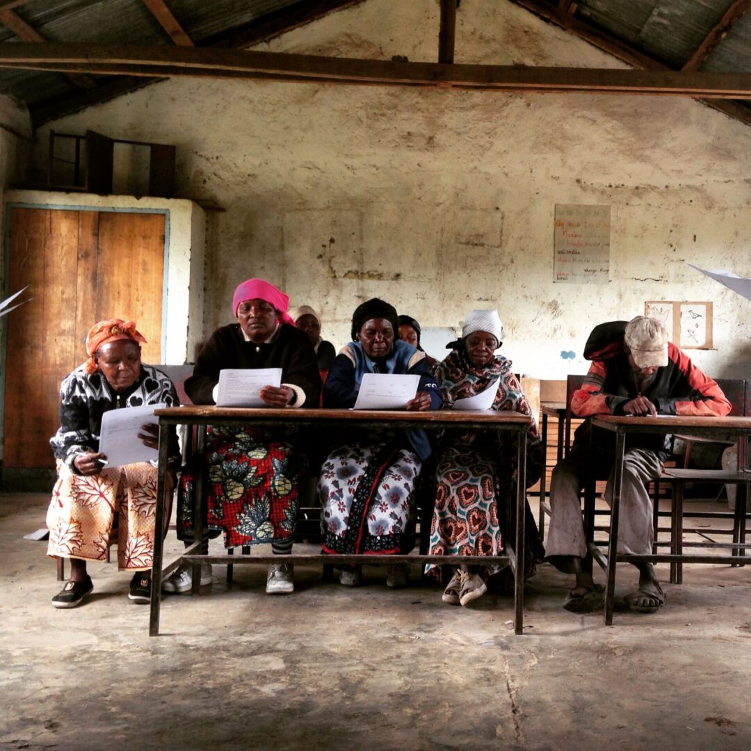 A group of people sitting at tables with laptops.