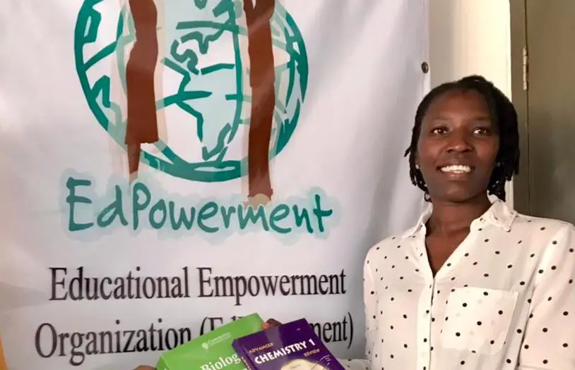 A woman standing in front of a banner with some food.