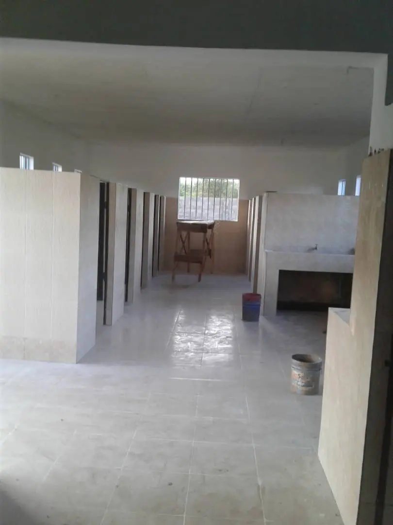 A hallway with white tile floors and walls.