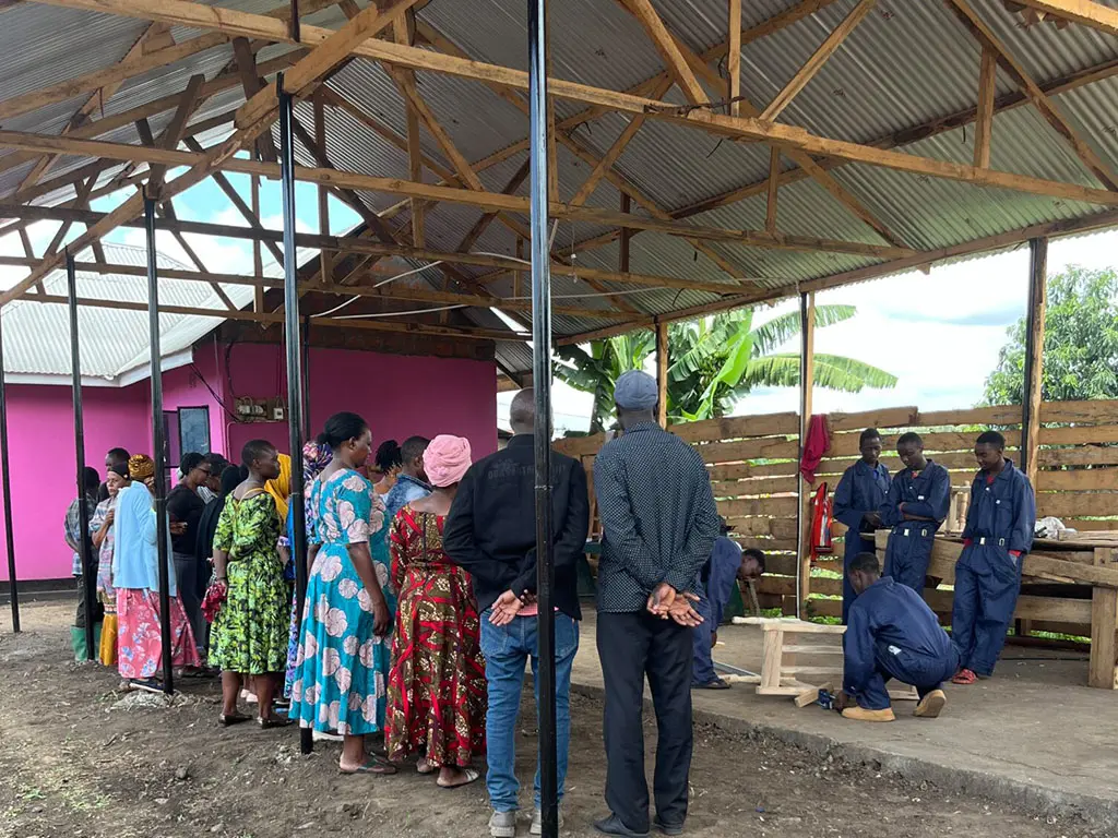 People gathered under a wooden structure.