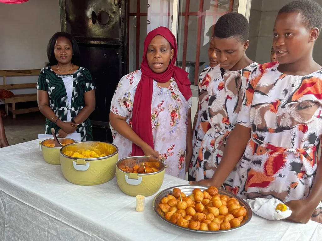 Women gathered around food on a table.