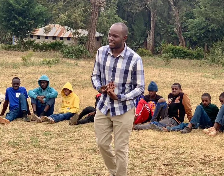 Man speaking to a group of young men.