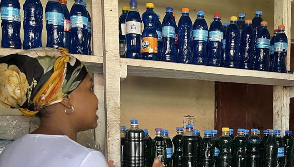 Woman shopping for bottled drinks on shelves.