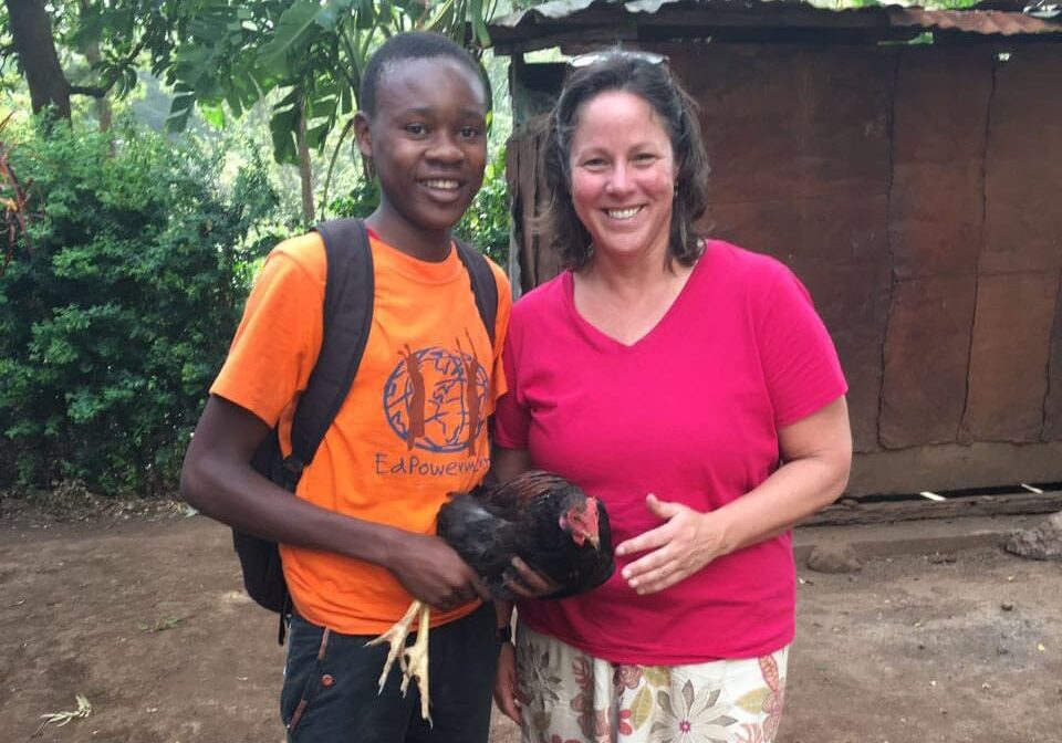 A woman and a boy holding a chicken.