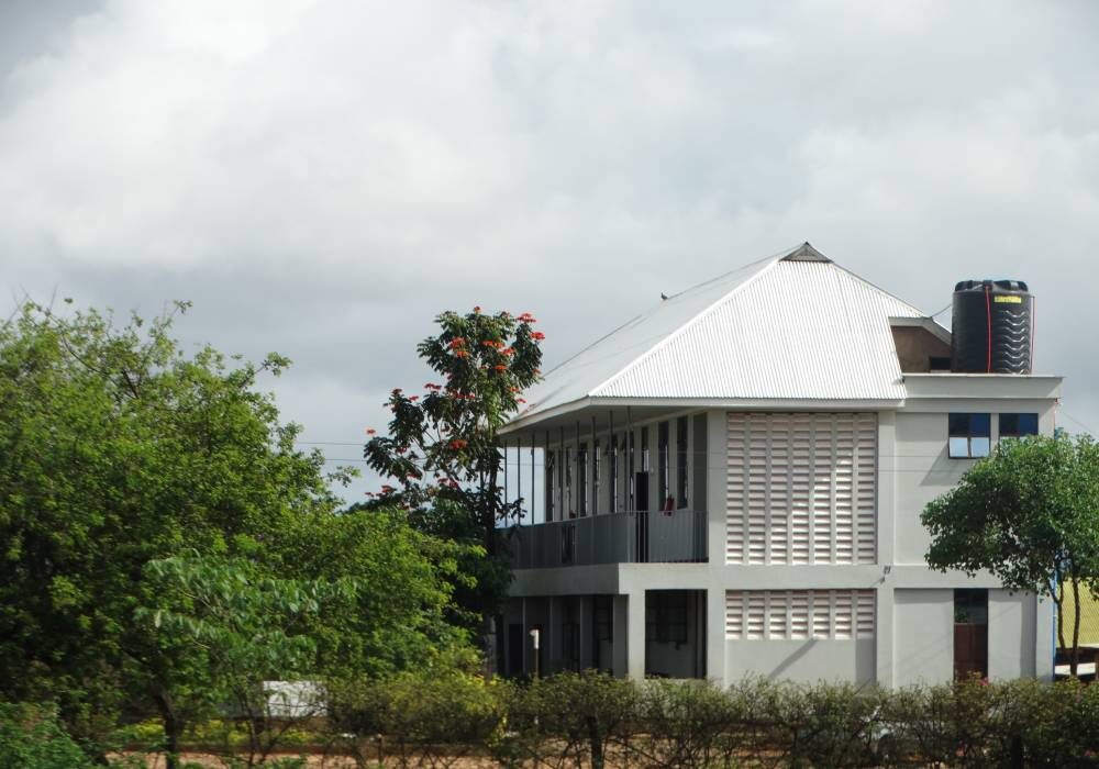 A white house with a large roof and a balcony.